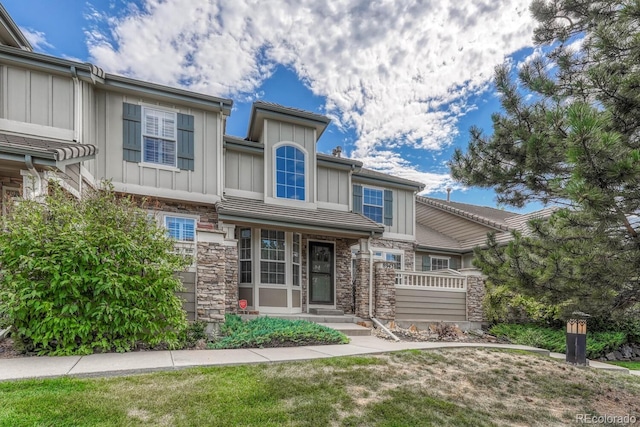 8943 Tappy Toorie Cir, Highlands Ranch, CO 80129 - view of front of home with board and batten siding, stone siding, and a front yard