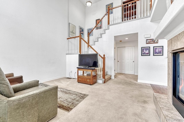 8943 Tappy Toorie Cir, Highlands Ranch, CO 80129 - living room featuring stairway, carpet, a towering ceiling, and baseboards