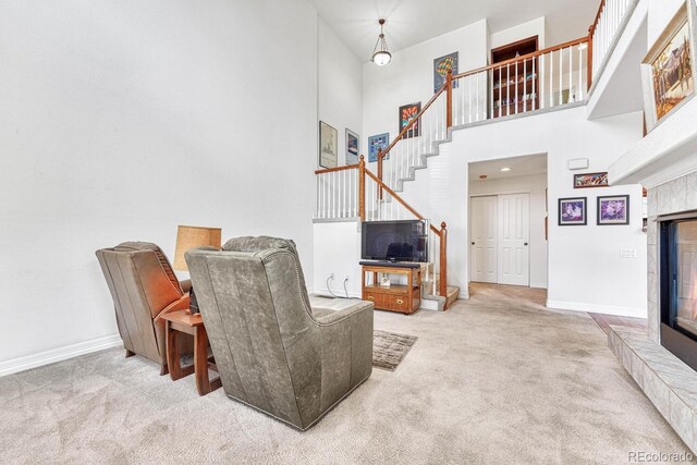 8943 Tappy Toorie Cir, Highlands Ranch, CO 80129 - carpeted living room with stairway, a towering ceiling, baseboards, and a tiled fireplace