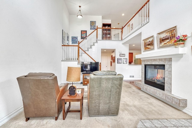 8943 Tappy Toorie Cir, Highlands Ranch, CO 80129 - carpeted living area featuring stairway, a high ceiling, baseboards, and a tiled fireplace