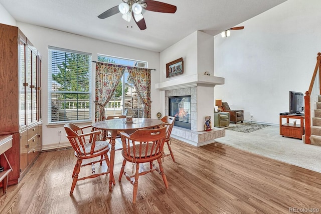 8943 Tappy Toorie Cir, Highlands Ranch, CO 80129 - dining space with a ceiling fan, a tile fireplace, stairway, wood finished floors, and baseboards