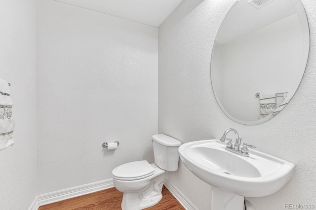 8943 Tappy Toorie Cir, Highlands Ranch, CO 80129 - half bath featuring wood finished floors, toilet, baseboards, and a sink