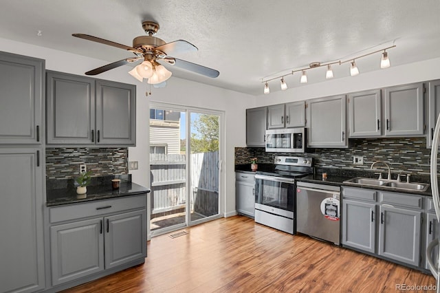 kitchen featuring gray cabinetry, appliances with stainless steel finishes, and a sink
