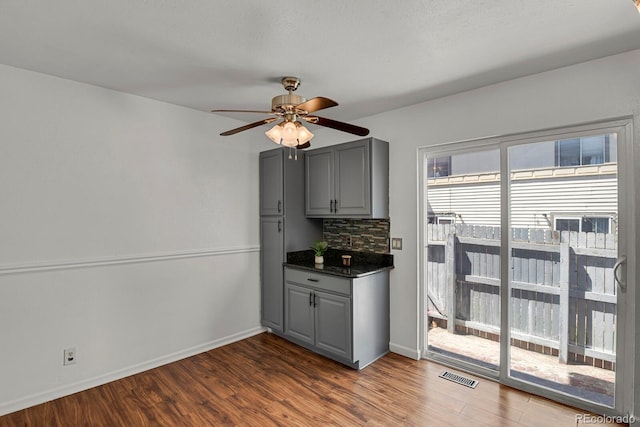 interior space with gray cabinetry, dark countertops, dark wood finished floors, and visible vents