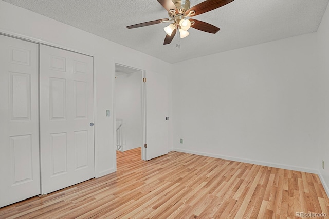 unfurnished bedroom with a textured ceiling, baseboards, ceiling fan, and light wood-type flooring