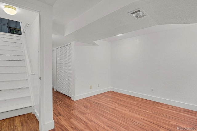 interior space with stairs, baseboards, visible vents, and light wood finished floors