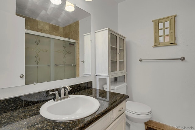 bathroom with vanity, a stall shower, and toilet