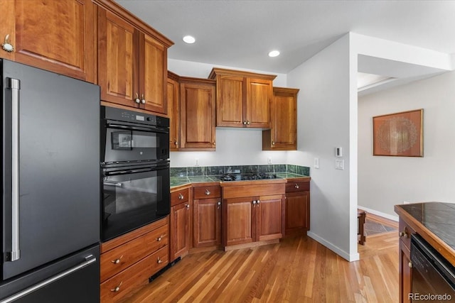 378 Fox Acres Dr W, Red Feather Lakes, CO 80545 - kitchen featuring black appliances, brown cabinetry, tile countertops, light wood finished floors, and recessed lighting