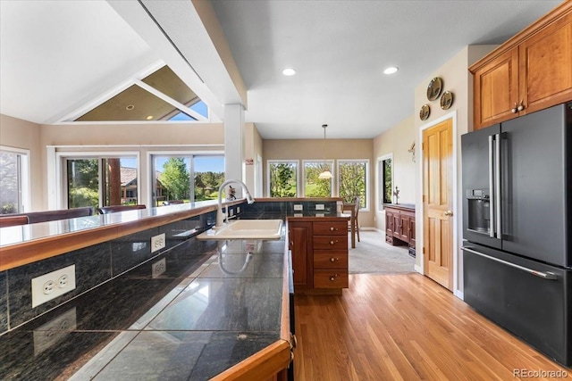 378 Fox Acres Dr W, Red Feather Lakes, CO 80545 - kitchen featuring high end fridge, light wood-style floors, brown cabinetry, lofted ceiling, and recessed lighting