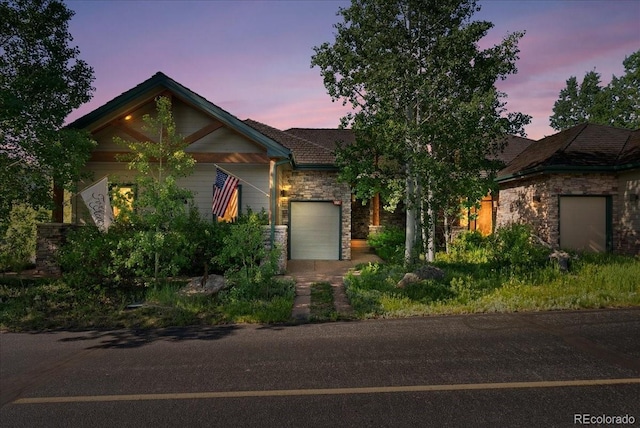 378 Fox Acres Dr W, Red Feather Lakes, CO 80545 - view of front of home featuring stone siding, an attached garage, and driveway