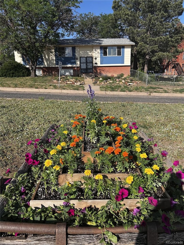 112 Main St, Walsenburg, CO 81089 - view of front of home featuring brick siding, fence, and a vegetable garden
