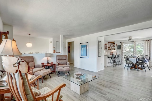 living room featuring a textured ceiling and light wood-type flooring