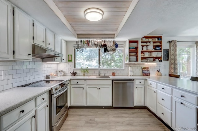 kitchen featuring appliances with stainless steel finishes, light hardwood / wood-style floors, white cabinets, and a wealth of natural light