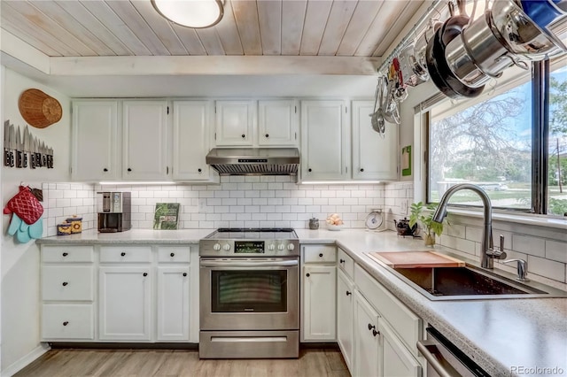 kitchen featuring white cabinets, light hardwood / wood-style floors, stainless steel appliances, tasteful backsplash, and sink