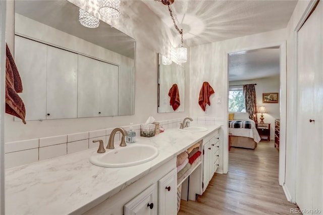 bathroom with large vanity, hardwood / wood-style flooring, double sink, and an inviting chandelier