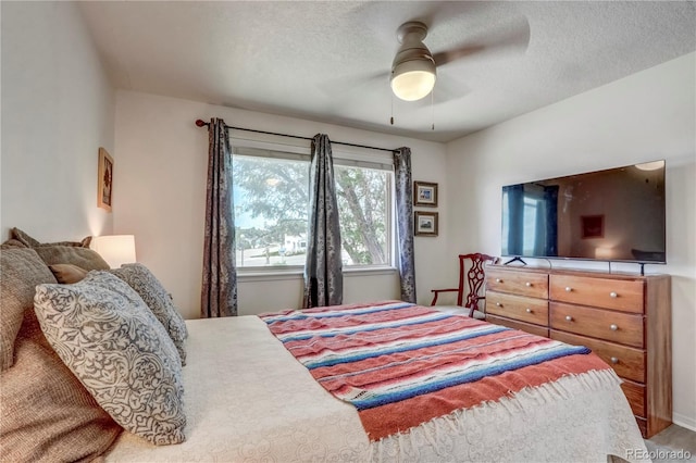 bedroom with ceiling fan and a textured ceiling