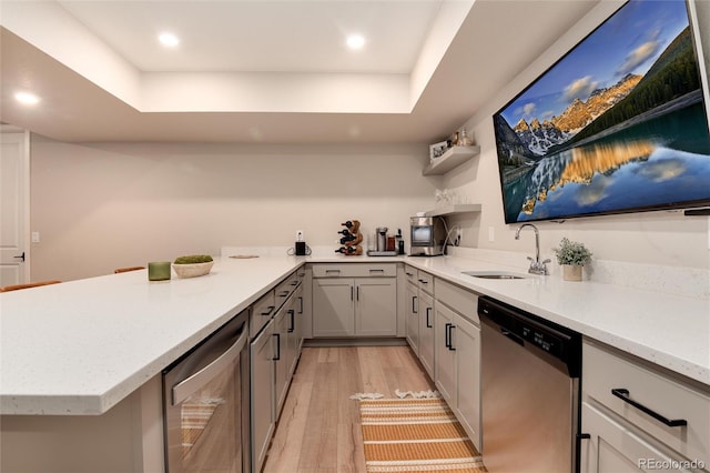 kitchen featuring gray cabinetry, dishwasher, light hardwood / wood-style flooring, and sink