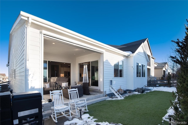 snow covered house featuring outdoor lounge area and a lawn