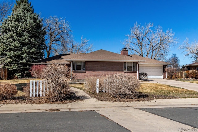 single story home featuring driveway, fence, a garage, brick siding, and a chimney