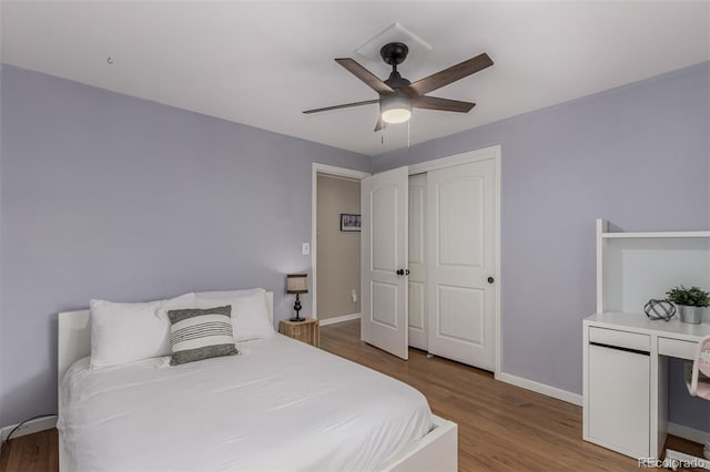 bedroom featuring a closet, baseboards, wood finished floors, and a ceiling fan