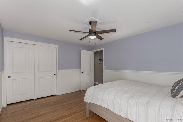 bedroom with a closet, wood finished floors, and a ceiling fan