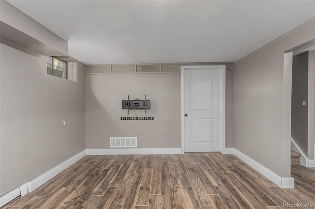 basement with visible vents, stairway, baseboards, and wood finished floors