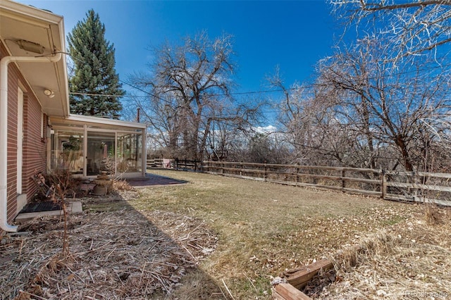 view of yard with a sunroom and fence