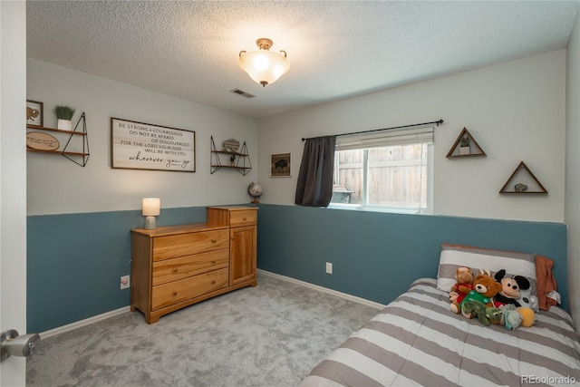 bedroom with light carpet, a textured ceiling, and baseboards