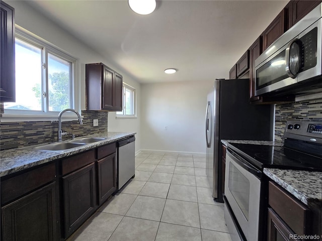 2865 Carnation Way, Thornton, CO 80229 - kitchen with stainless steel appliances, tasteful backsplash, light tile patterned floors, and dark brown cabinetry