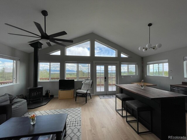 69 Noxibee Ct, Como, CO 80432 - living room featuring a wood stove, light wood-type flooring, ceiling fan, lofted ceiling, and a chandelier