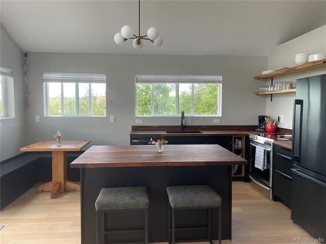 69 Noxibee Ct, Como, CO 80432 - kitchen with butcher block countertops, black refrigerator, stainless steel electric range, light wood finished floors, and healthy amount of natural light