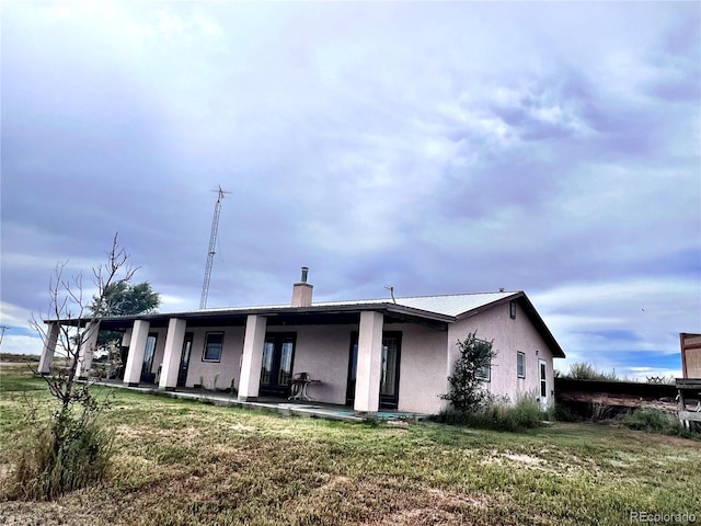 rear view of property with a lawn