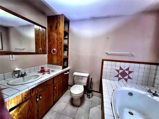 bathroom featuring toilet, vanity, a bath, and tile patterned flooring