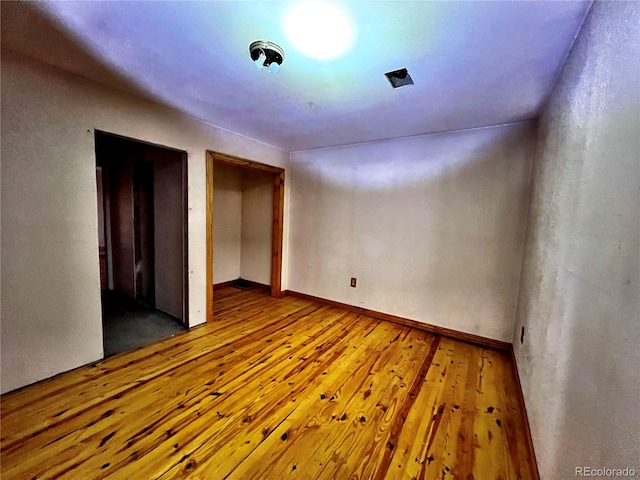 empty room with hardwood / wood-style flooring