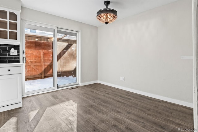 spare room featuring wood-type flooring