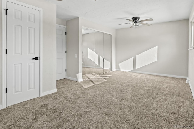 carpeted spare room featuring ceiling fan