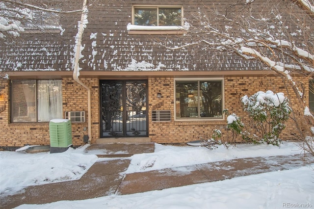 snow covered property entrance with central AC