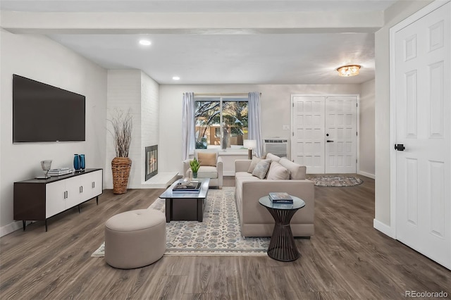 living room with a brick fireplace, dark hardwood / wood-style flooring, and beamed ceiling