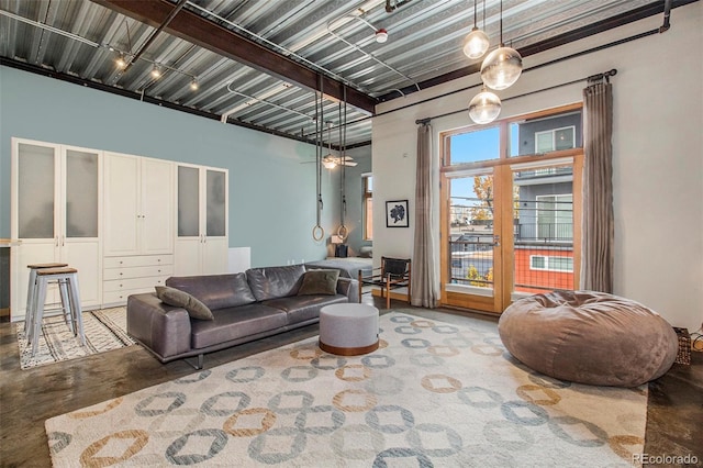 living room with concrete flooring and a towering ceiling