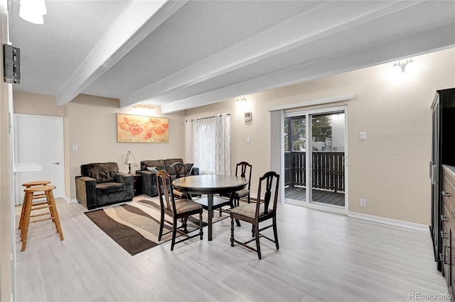 dining area featuring beamed ceiling, a textured ceiling, and light hardwood / wood-style floors