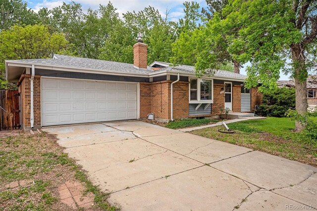 8269 Zephyr St, Arvada, CO 80005 - ranch-style home featuring brick siding, an attached garage, driveway, and a chimney