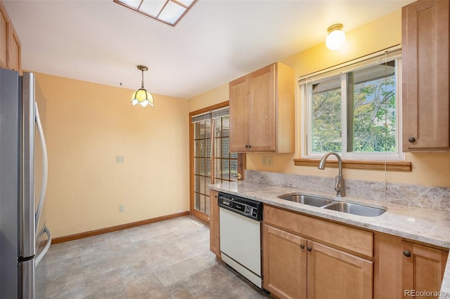 8269 Zephyr St, Arvada, CO 80005 - kitchen featuring dishwasher, freestanding refrigerator, a sink, baseboards, and light stone countertops