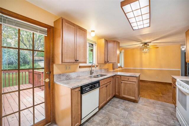 8269 Zephyr St, Arvada, CO 80005 - kitchen featuring a sink, white appliances, a peninsula, a ceiling fan, and baseboards