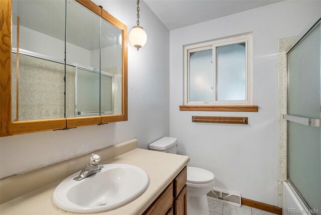 8269 Zephyr St, Arvada, CO 80005 - bathroom featuring a shower with shower door, toilet, vanity, and baseboards
