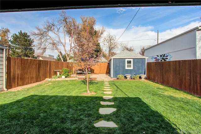 view of yard featuring a storage shed, an outdoor structure, and a fenced backyard