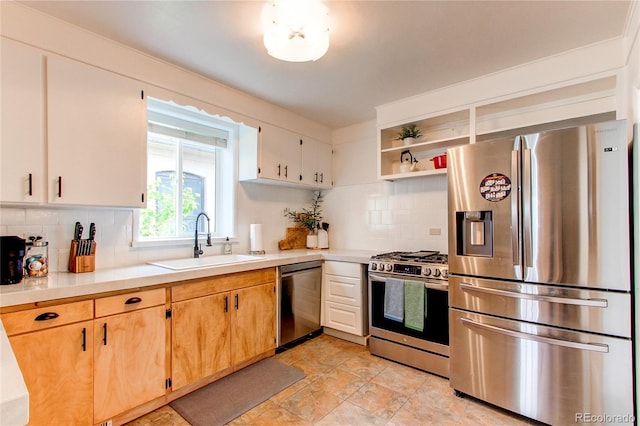 kitchen with light countertops, appliances with stainless steel finishes, a sink, and tasteful backsplash