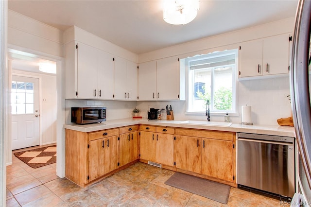 kitchen with a sink, decorative backsplash, dishwasher, and light countertops