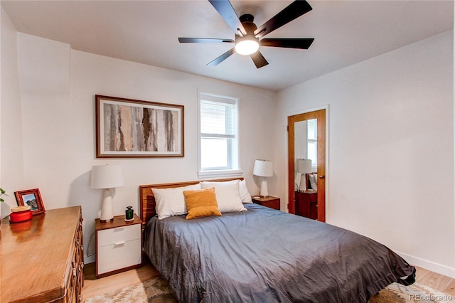 bedroom featuring baseboards, ceiling fan, and light wood-type flooring