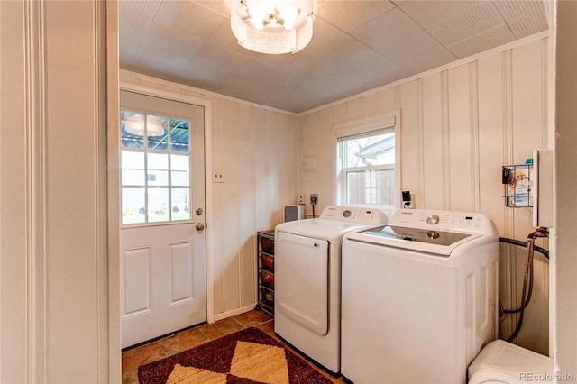 laundry room with crown molding, laundry area, stone finish floor, and washer and clothes dryer