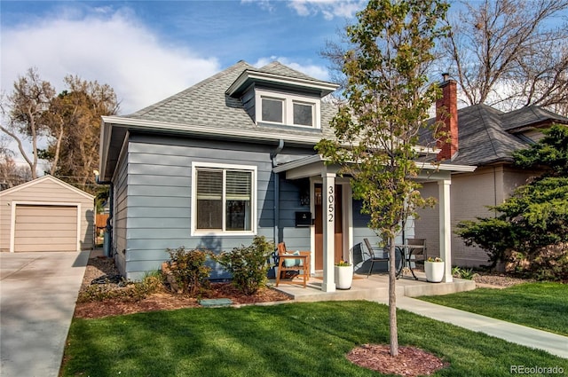 bungalow-style house featuring an outbuilding, a porch, driveway, and a front yard